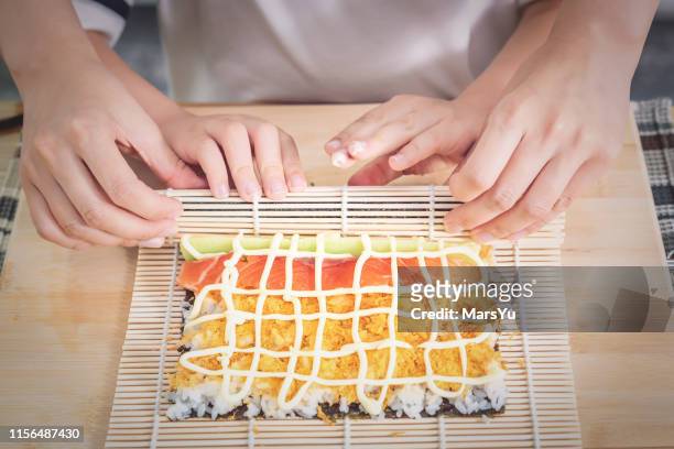 junge junge lernen, sushi handrolle zu machen - nori stock-fotos und bilder