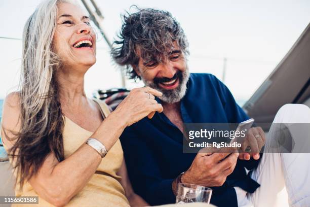 couple using phone on a cruise - luxury cruise relaxing stock pictures, royalty-free photos & images