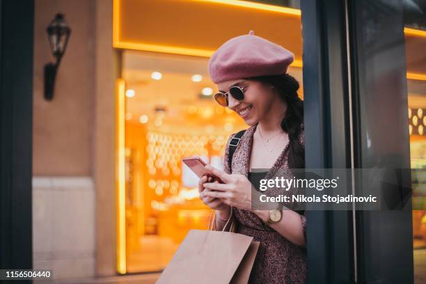 mooie vrouw bedrijf boodschappentassen en glimlachen - airport shopping stockfoto's en -beelden