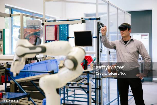 industry 4.0: engineer works with a head-mounted display - industry 4 0 imagens e fotografias de stock