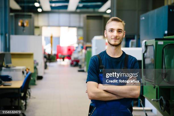 porträt: junger techniker in einer industriehalle - mechanic stock-fotos und bilder