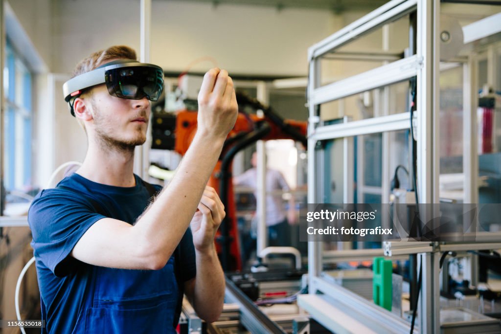 Industry 4.0: Young engineer works with a head-mounted display