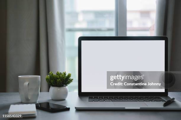 laptop with blank white screen and office supply items on word desk - phone still life stock pictures, royalty-free photos & images