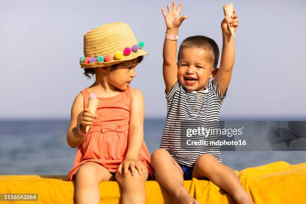 junge und ein mädchen genießen eis am strand - boy and girl eating ice cream stock-fotos und bilder