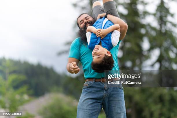 dad playing with his son at the park - rough housing imagens e fotografias de stock