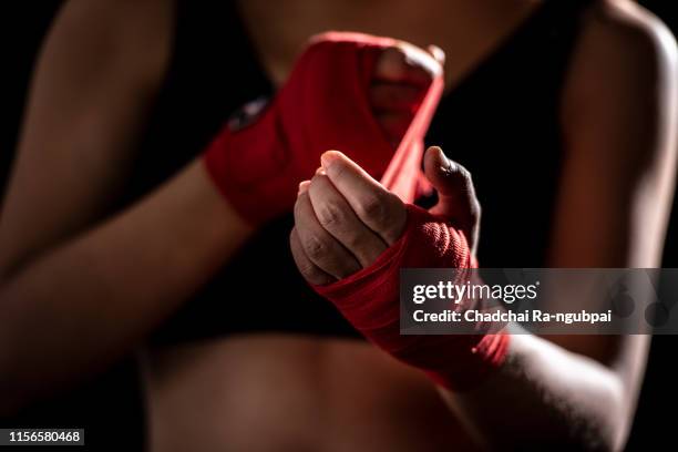 health care women are exercising by punching and are wrapped in red cloth at the hands before punching in the gym. - mixed martial arts woman stock pictures, royalty-free photos & images