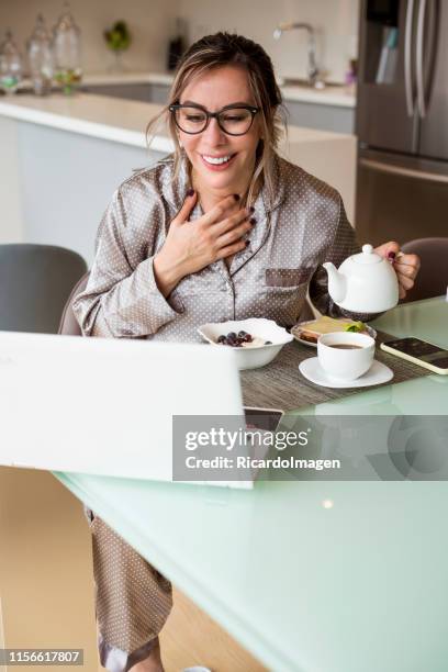 woman checking the computer while having breakfast - colombia business breakfast meeting stock pictures, royalty-free photos & images