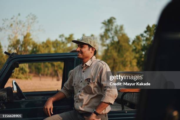 man standing by the safari vehicle - bandhavgarh national park stock pictures, royalty-free photos & images