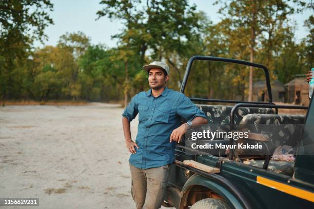 man standing by the safari vehicle - indian ethnicity man car stock pictures, royalty-free photos & images