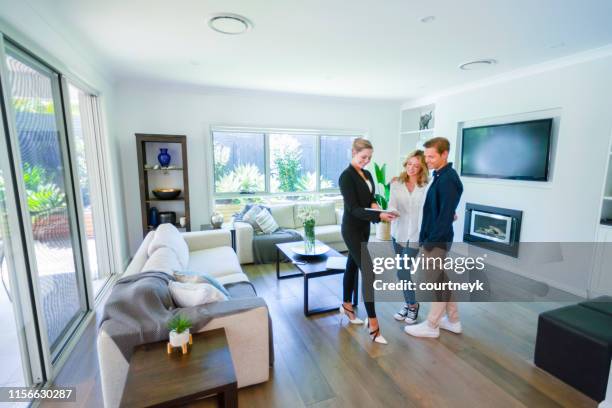 real estate agent with couple in luxury home. - house viewing stock pictures, royalty-free photos & images