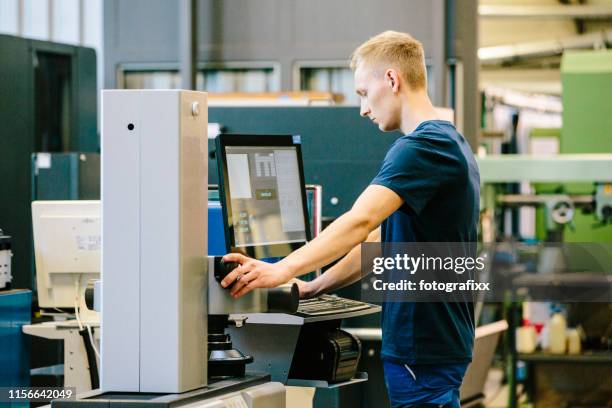 industry 4.0: young engineer control his work on a cnc machine - trainee program stock pictures, royalty-free photos & images