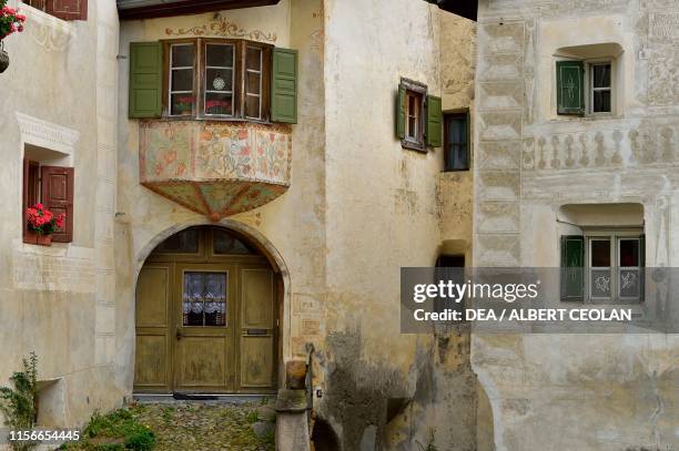 Entrance of a house with small bow window, Guarda, Scuol, Engadin, Canton of Graubunden, Switzerland.