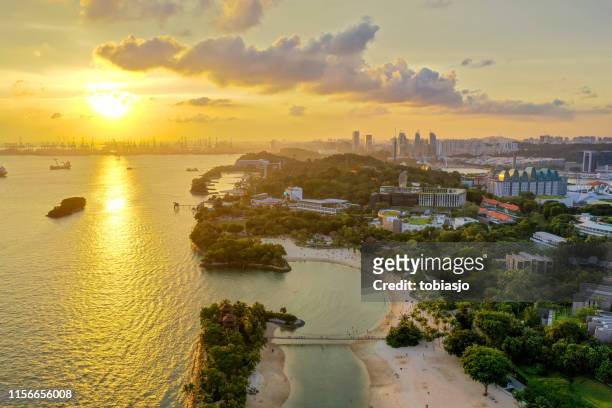 sentosa beach in singapore at sunset - sentosa island singapore stock pictures, royalty-free photos & images