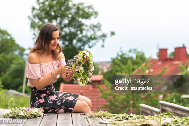 mujer haciendo una corona de flores en pleno verano en suecia - swedish culture fotografías e imágenes de stock