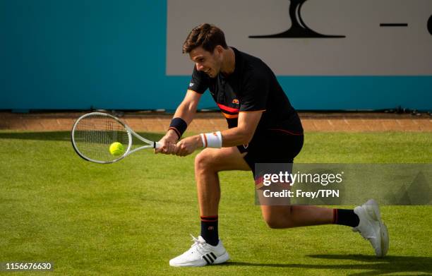 Cameron Norrie of Great Britain hits a backhand against Kevin Anderson of South Africa during day 1 of the Fever-Tree Championships at Queens Club on...
