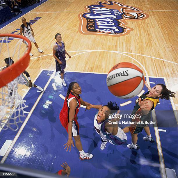 East All Star Dawn Staley of the Charlotte Sting shoots between West All Stars Tina Thompson of the Houston Comets and Sue Bird of the Seattle Storm...