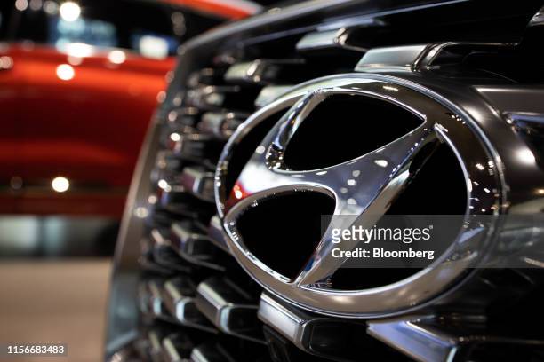 The Hyundai Motor Co. Badge is displayed on the front grille of a Palisade sport utility vehicle at the company's Motorstudio showroom in Goyang,...