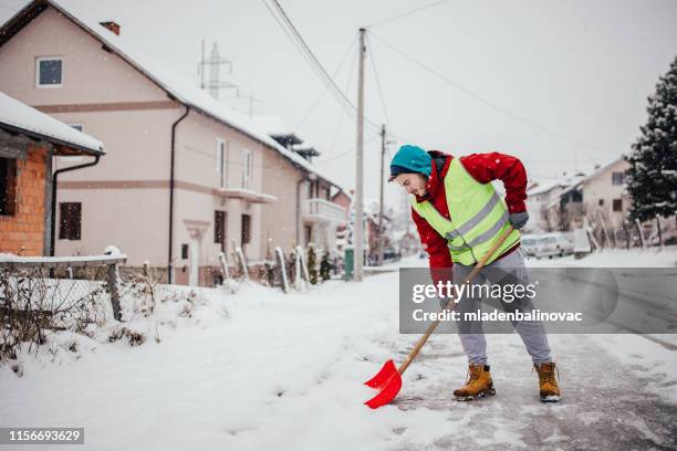 man with snow shovel - snow shovel man stock pictures, royalty-free photos & images