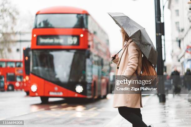 woman waiting on a bus station while double decker bus approaching - london buses stock pictures, royalty-free photos & images