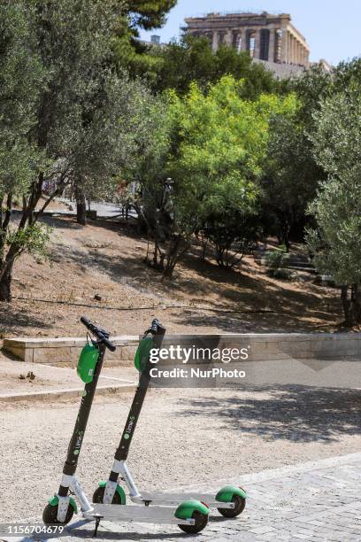 Lime-S electric scooters during a day with sun, in a stack fully charged, stand by at the Greek capital, Athens below the Parthenon in the Acropolis,...