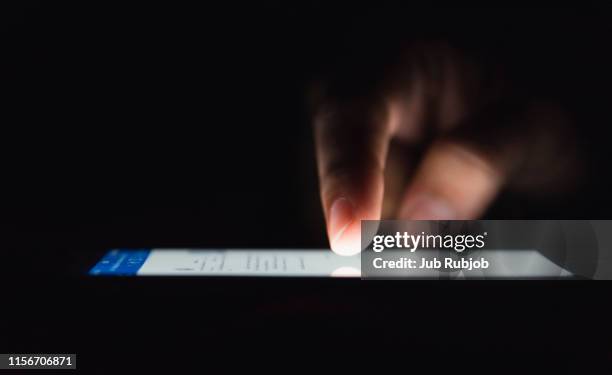 woman looking up social medial at late night lying in bed, internet addicted - facebook bildbanksfoton och bilder