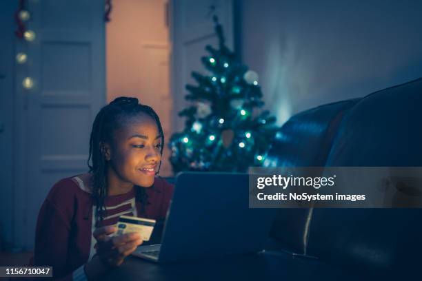 young african woman shopping online at home - christmas budget stock pictures, royalty-free photos & images