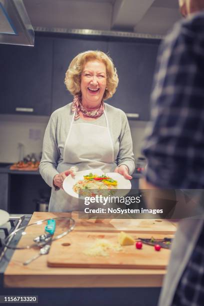 senior lady, an attendee of cooking class with risotto - testimonial stock pictures, royalty-free photos & images