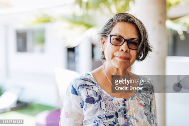 immagine di donna latinx anziana sana con capelli grigi e occhiali. - introspection foto e immagini stock