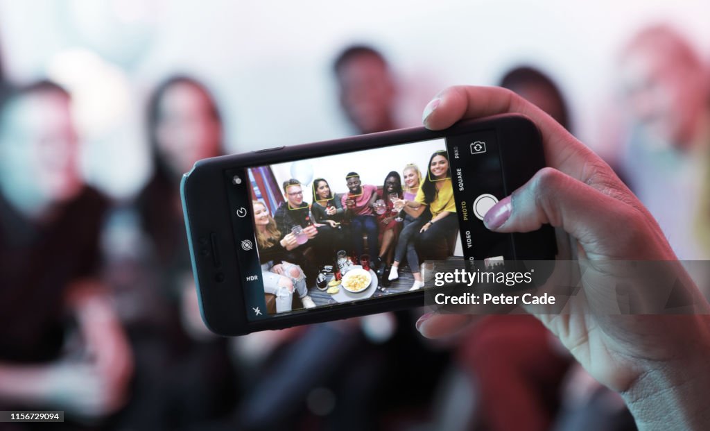 Taking photo of young people at house party