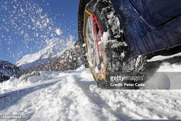 snow chains on car tyre - eislandschaft stock-fotos und bilder