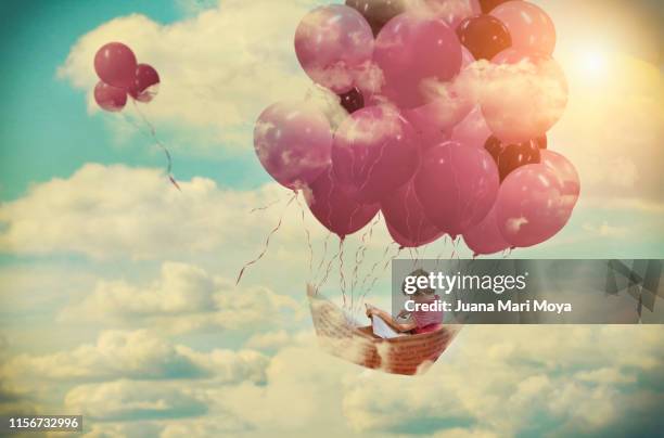 digital composition, of a boy flying on a paper boat fastened by pink balloons - daydreaming fantasy stock pictures, royalty-free photos & images