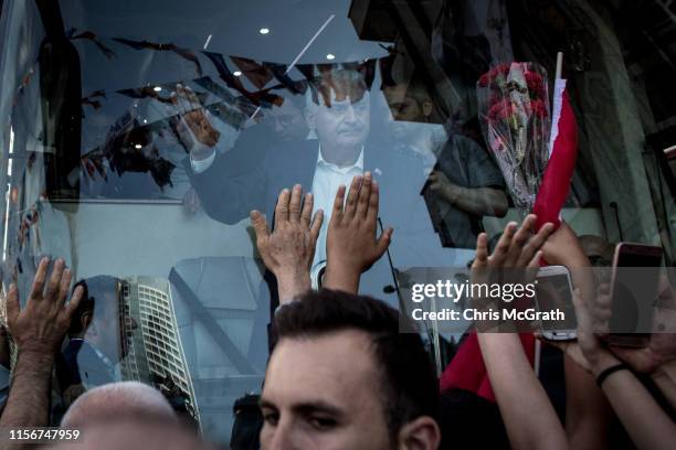 Istanbul mayoral candidate Binali Yildirim of the ruling Justice and Development Party waves to supporters from his bus during a campaign street stop...