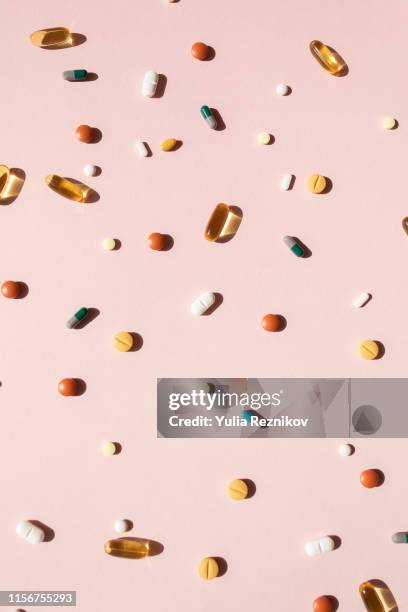 top view of various pills and tablets on the pink background - space capsule fotografías e imágenes de stock