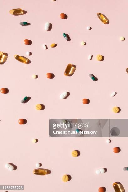 top view of various pills and tablets on the pink background - complément vitaminé photos et images de collection
