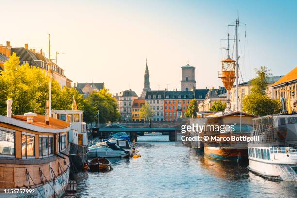 moored boats along a narrow canal in copenhagen old town, denmark - copenhagen stock pictures, royalty-free photos & images