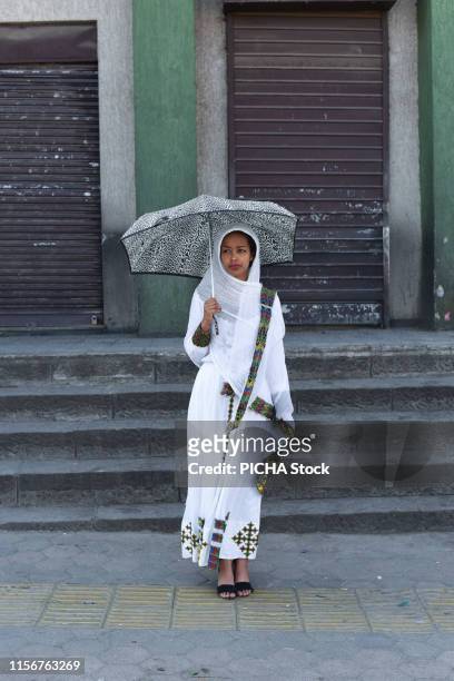 Woman standing in the street with an umbrella