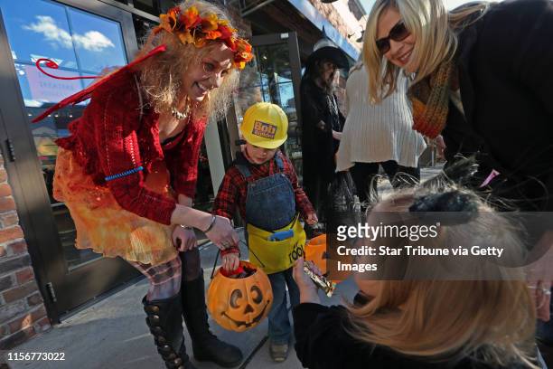 Dressed as a fairy, Lauren Asheim, employee at Prana Apparel handed out candy to Will Snell, age 4 and Maddy Snell, age 18 months as mom, Jen Snell...