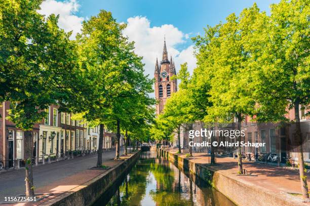 canal with leaning church tower in delft netherlands - delft stock pictures, royalty-free photos & images