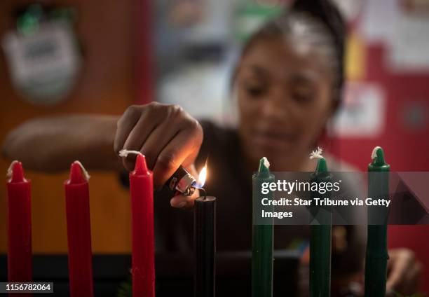 Kamora Shambley lite the first of seven candles during a celebration of the first day of Kwanzaa at the Martin Luther King Recreation Center...