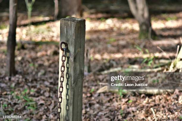 rusted chain hanging on wooden post - chain fence stock pictures, royalty-free photos & images