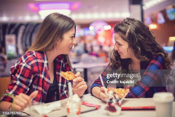 schöne teenager-mädchen essen im restaurant - girl after shopping stock-fotos und bilder