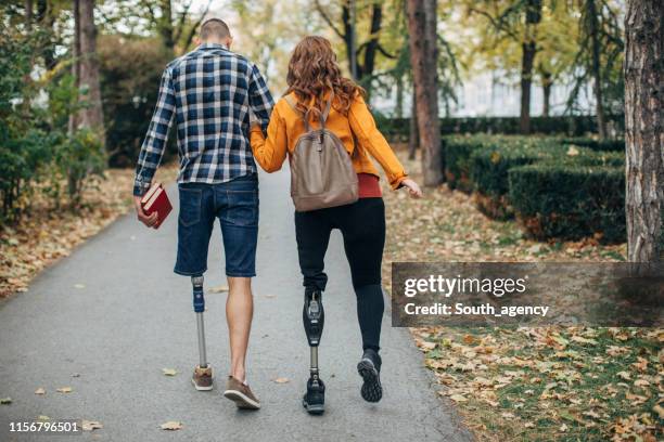 handicap paar wandelen in het park - couple school stockfoto's en -beelden