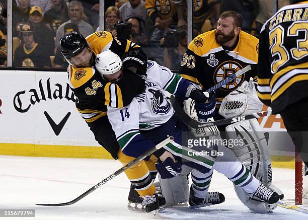 Dennis Seidenberg of the Boston Bruins tackles Alex Burrows of the Vancouver Canucks after an incident with Tim Thomas of the Boston Bruins during...