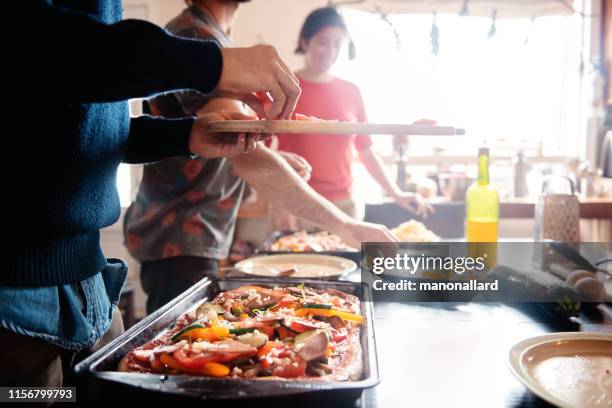 Millenial multi-ethnic roommates cooking vegetalian, vegan pizza