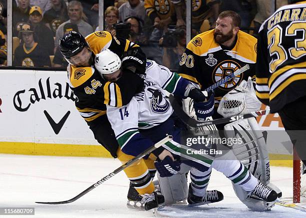 Dennis Seidenberg of the Boston Bruins tackles Alex Burrows of the Vancouver Canucks after an incident with Tim Thomas of the Boston Bruins during...