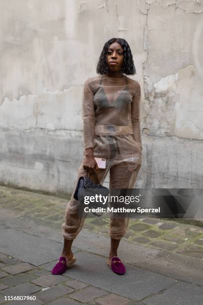 Guest is seen on the street attending Men's Paris Fashion Week wearing sheer outfit with black bag and burgundy slides on June 18, 2019 in Paris,...