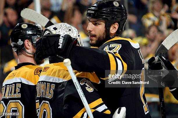 Milan Lucic of the Boston Bruins congratulates goaltender Tim Thomas aftertheir 4-0 victory over the Vancouver Canucks in Game Four of the 2011 NHL...