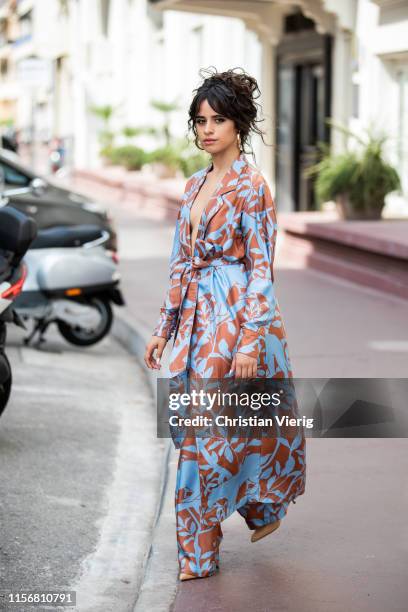 Camila Cabello is seen wearing pants and belted coat Johanna Ortiz on June 18, 2019 in Cannes, France.