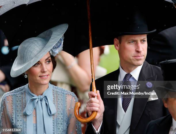 Catherine, Duchess of Cambridge and Prince William, Duke of Cambridge shelter under an umbrella as they attend day one of Royal Ascot at Ascot...