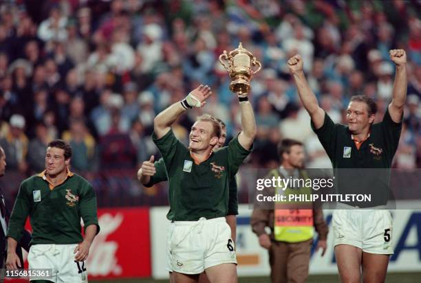 Picture taken on June 24, 1995 at Johannesburg showing South African captain François Pienaar brandishing the William Webb Ellis trophy and saluting...